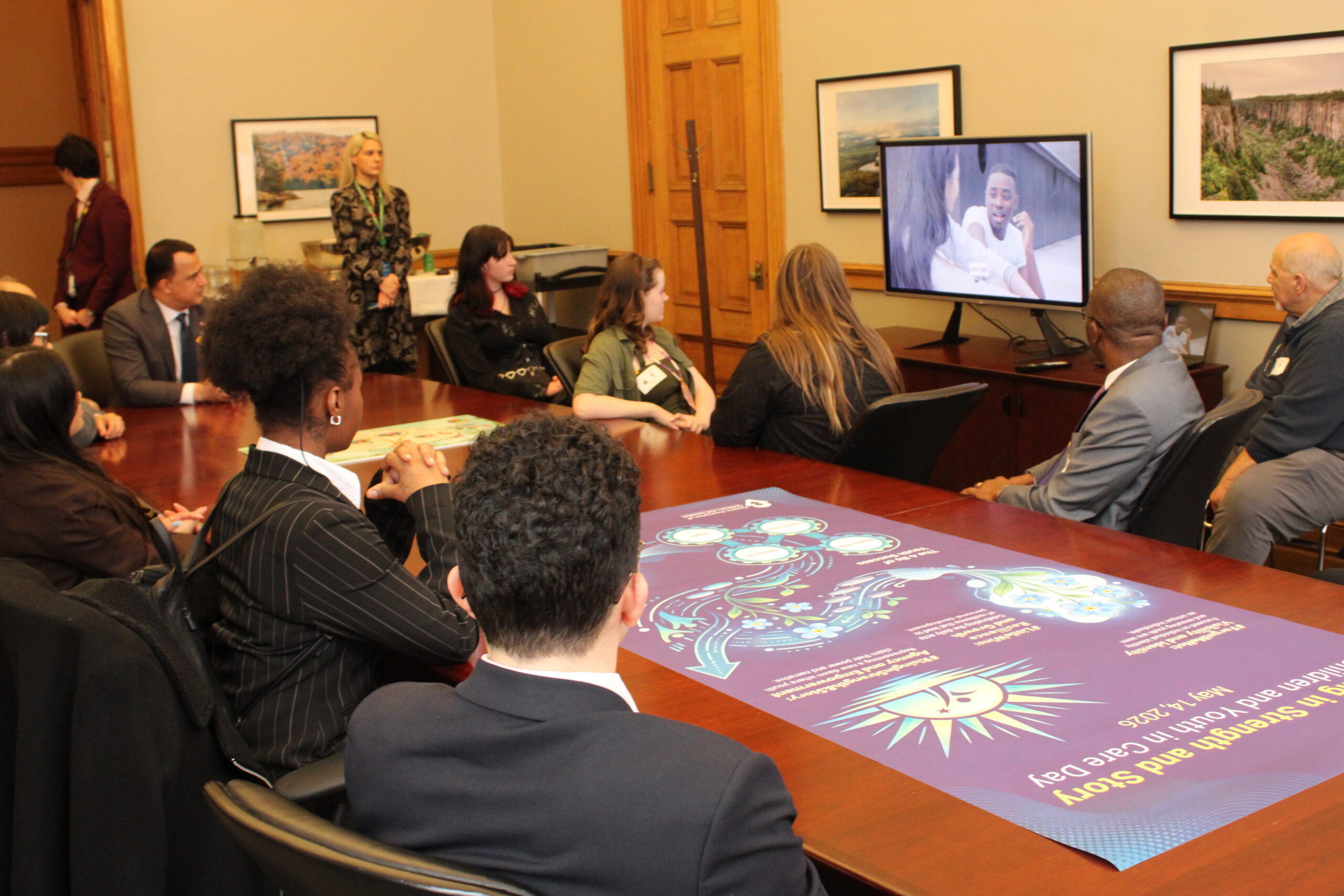 Youth, Minister Parsa, OACAS staff watch "Rising in Strength and Story" video at Children and Youth in Care Day, May 14, 2026.